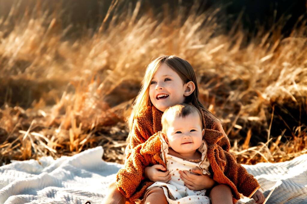 Two sisters in a photo showing off their fall photoshoot outfits.