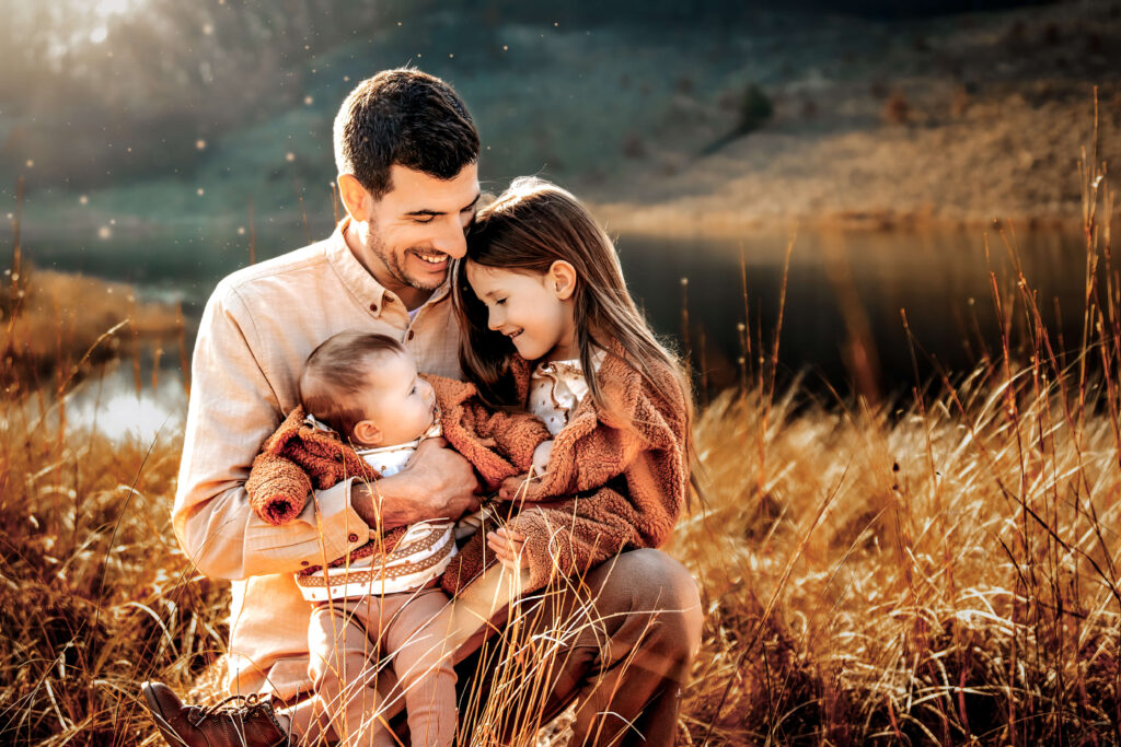 Fall family photoshoot showing dad and kids cuddling.