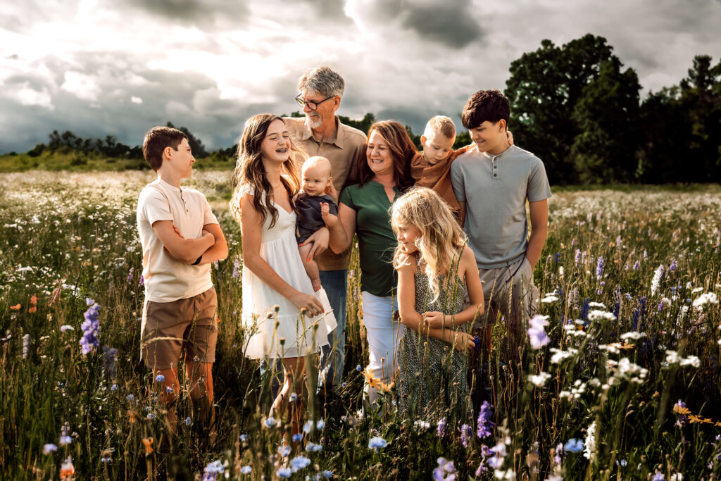 A family photoshoot in a flower field, dressed in soft earth tones and warm neutrals from the Cedar Rose color palette, creating a cohesive, organic look for spring.